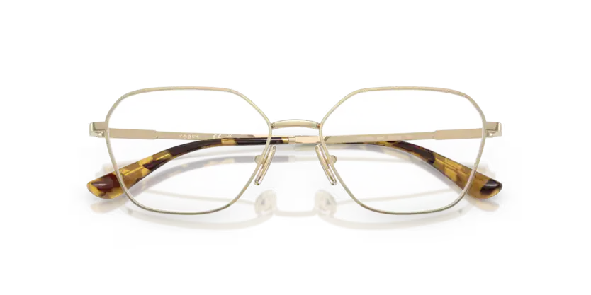 Gold-framed eyeglasses with tortoiseshell accents on a clear background