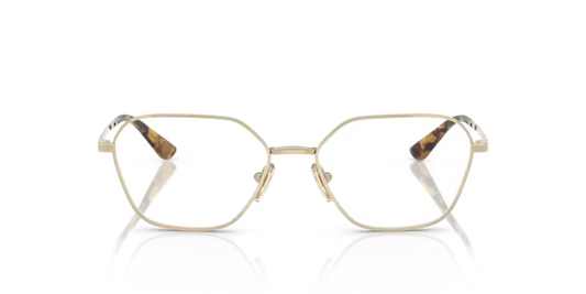 Gold-framed eyeglasses with tortoiseshell accents on a reflective surface