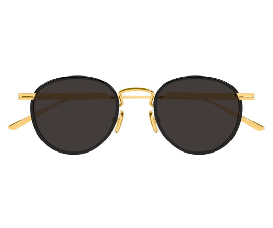Round sunglasses with gold frame and dark lenses on a white background