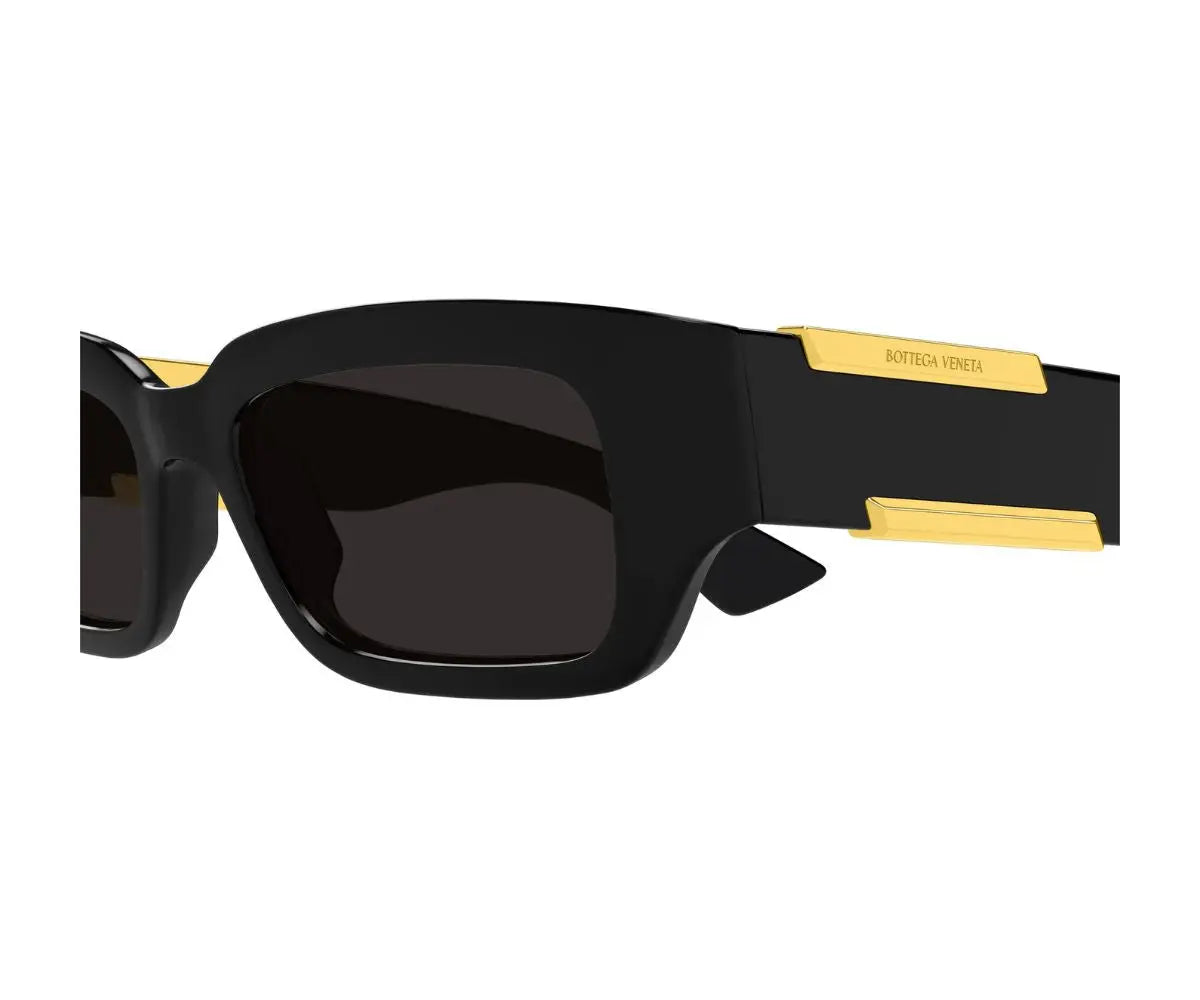 Black sunglasses with gold accents on a white background
