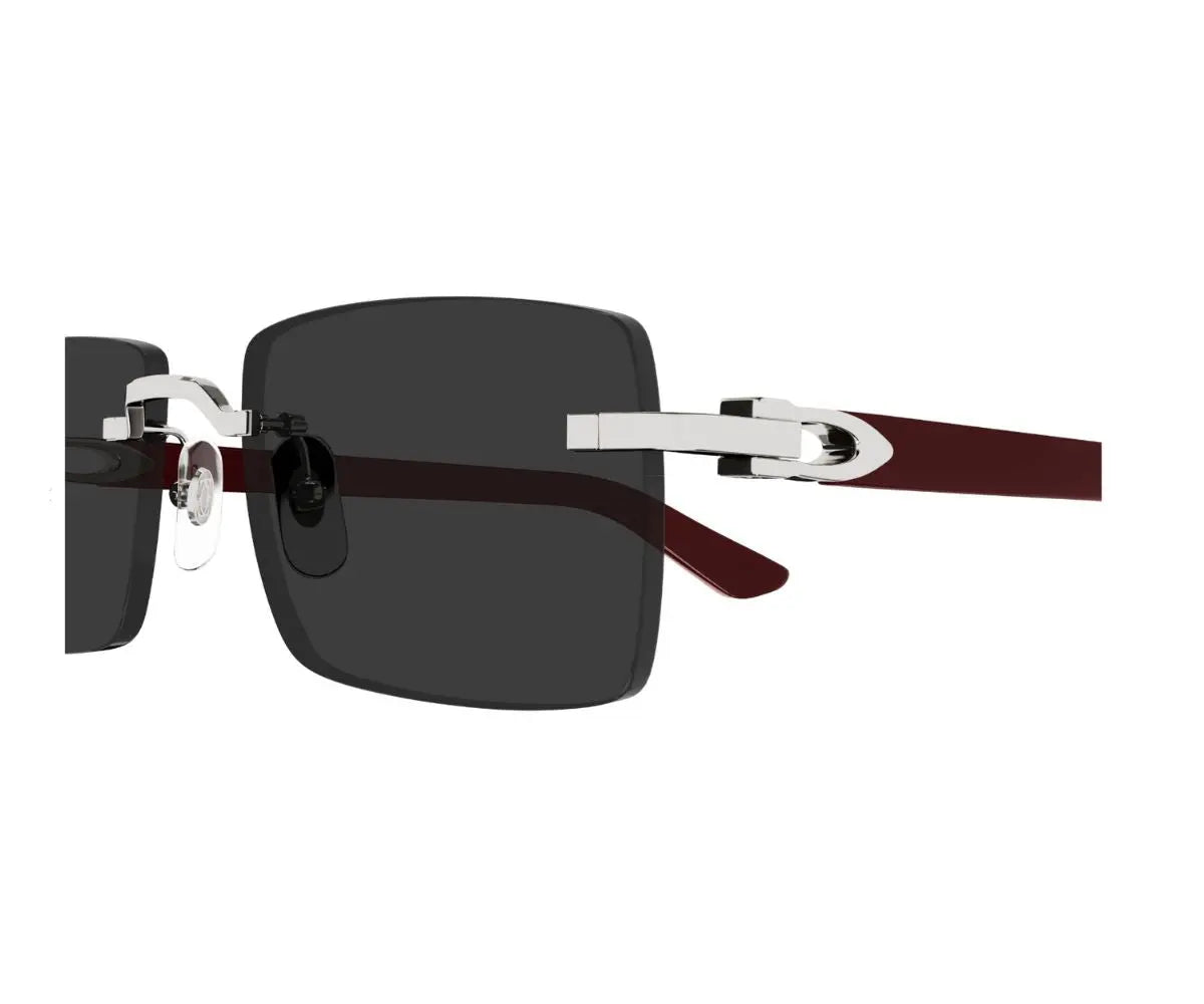 Sunglasses with a dark lens and brown and silver frame on a white background