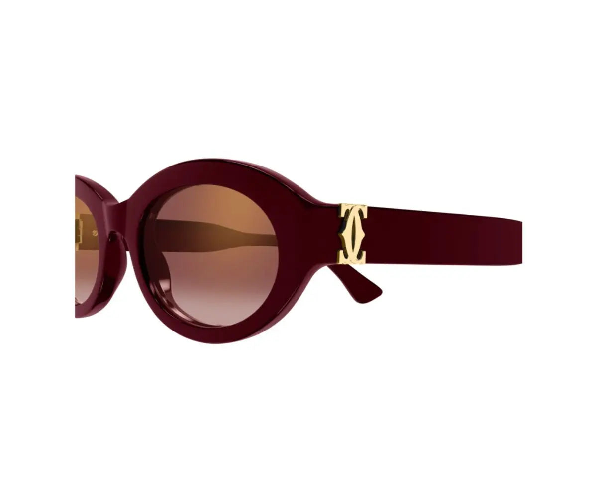 Sunglasses with a maroon frame and gold accents on a white background