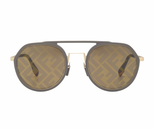 Sunglasses with a gold frame and dark lenses on a white background