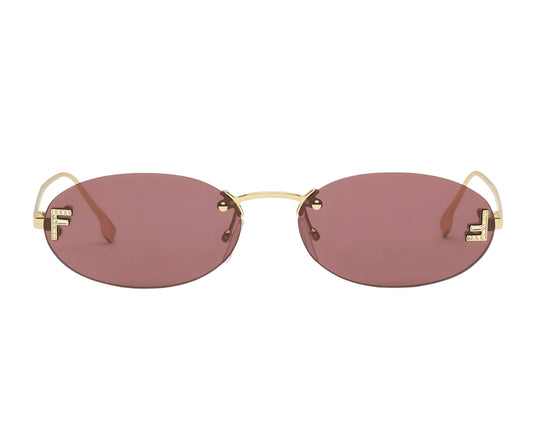 Sunglasses with gold frame and red-tinted lenses on a white background
