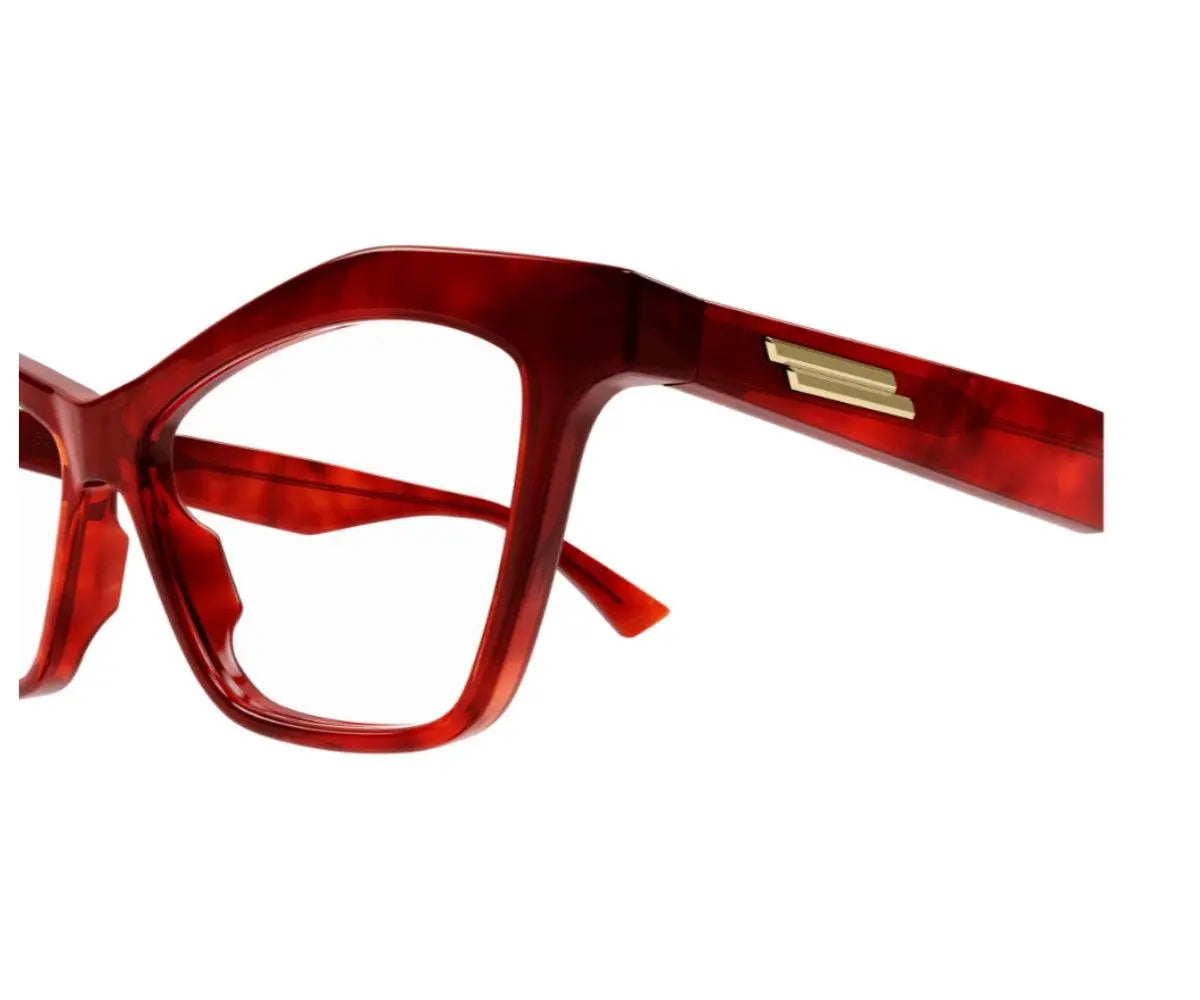 Red eyeglasses with a gold temple piece on a white background