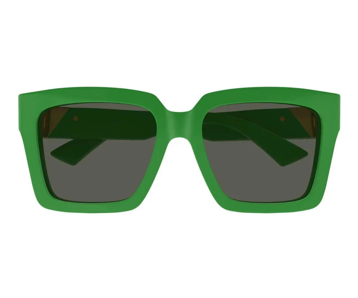 Green sunglasses with dark lenses on a white background