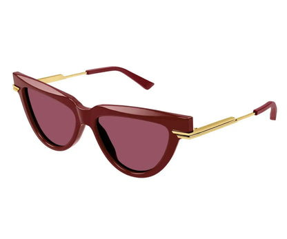 Sunglasses with maroon lenses and gold frames on a white background
