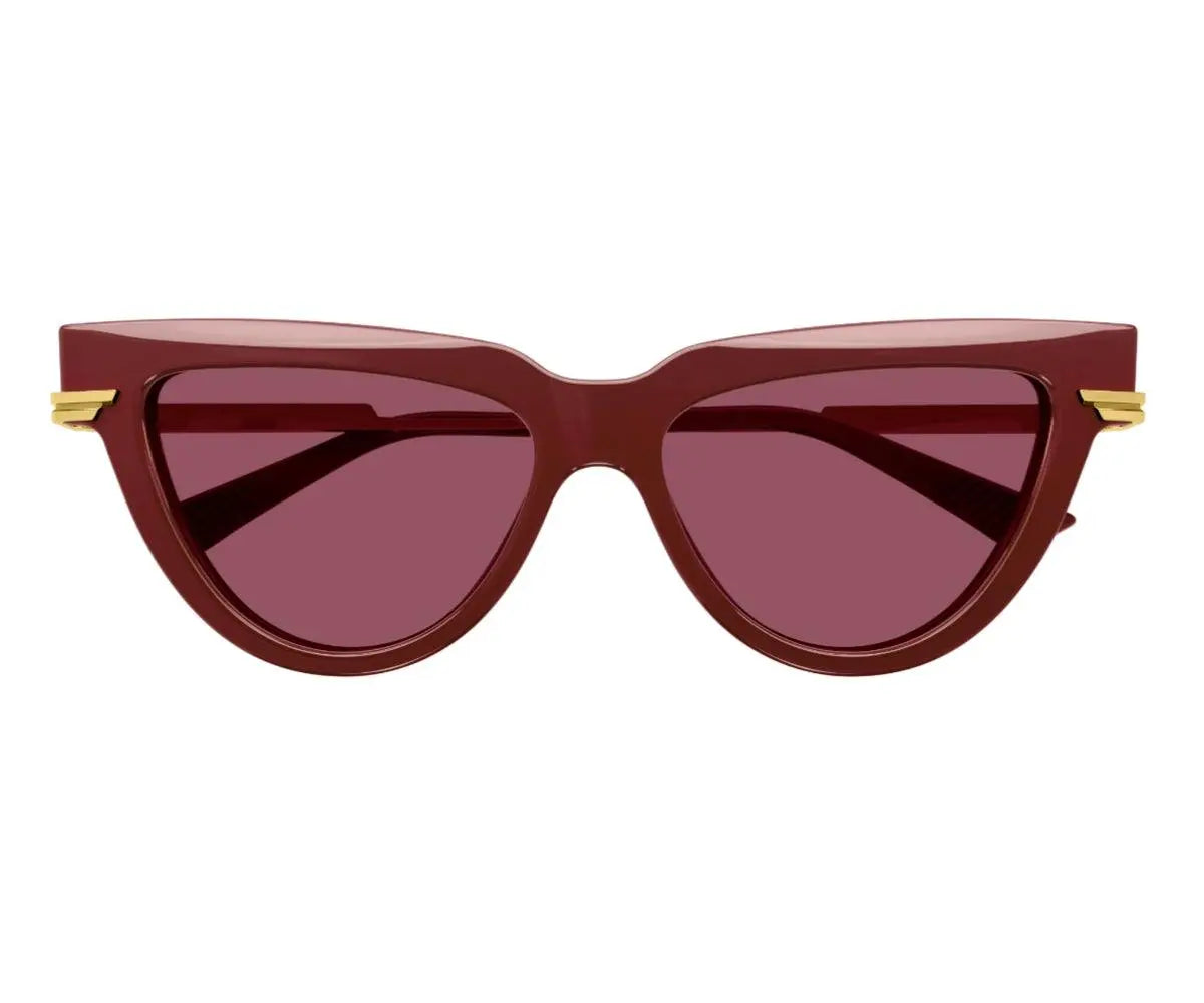 Red cat-eye sunglasses with gold accents on a white background