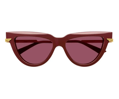 Red cat-eye sunglasses with gold accents on a white background