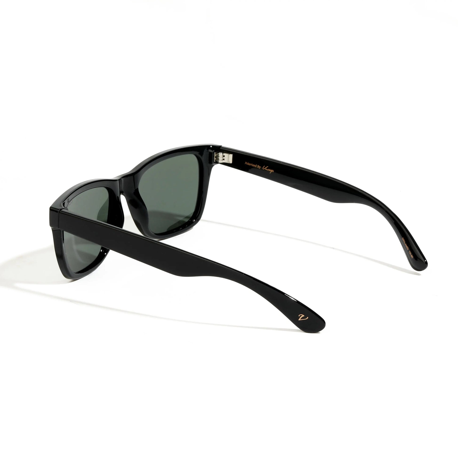 Black sunglasses with green lenses on a white background