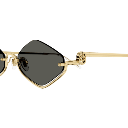 Gold-framed sunglasses with black lenses on a transparent background