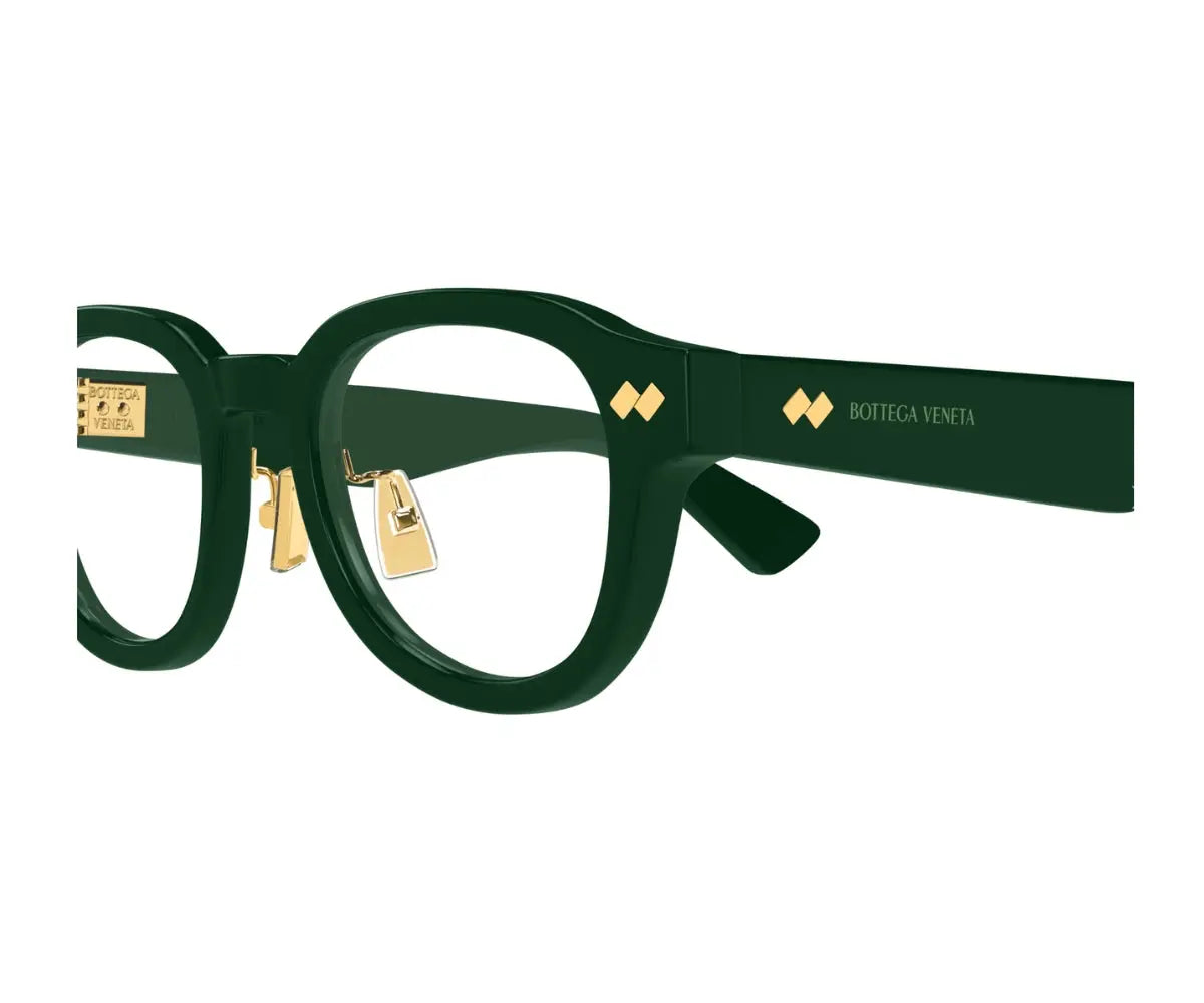 Green eyeglasses with gold accents on a white background
