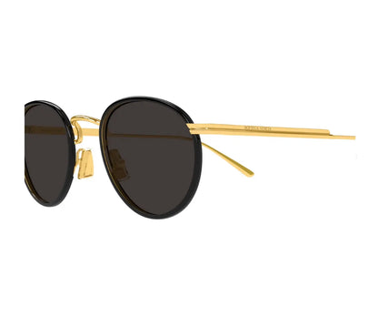 Sunglasses with gold frame and dark lenses on a white background