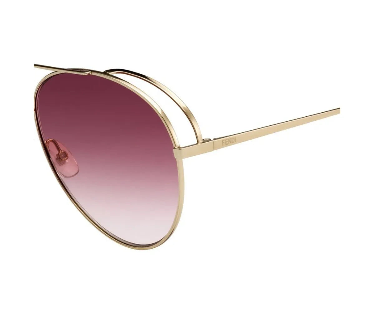 Gold-framed sunglasses with pink gradient lenses on a white background