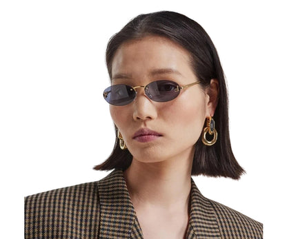 Woman wearing sunglasses and gold earrings on a white background