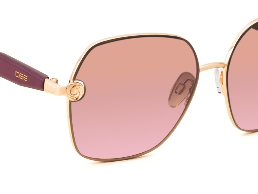 Sunglasses with pink gradient lenses and gold frame on a white background