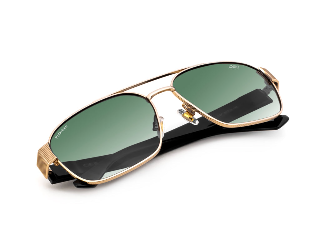Gold-framed sunglasses with green lenses on a white background