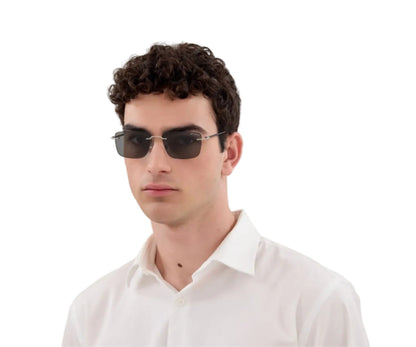 Man wearing dark sunglasses and a white shirt on a white background