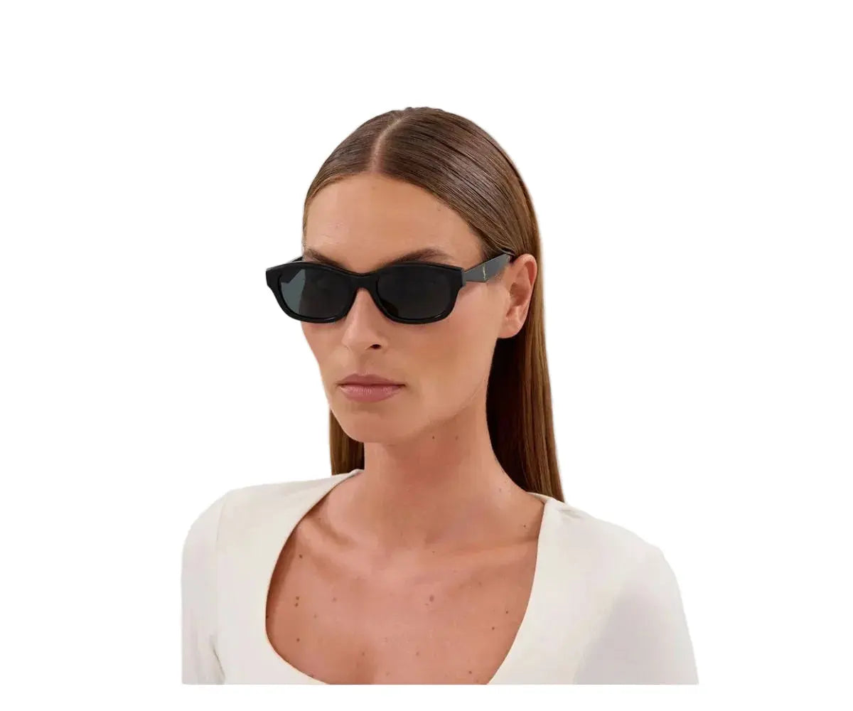 Woman wearing black cat-eye sunglasses on a white background