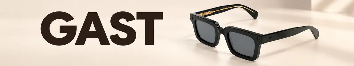 GAST NOT COMMON NC01 49 black sunglasses with grey lenses beside GAST branding on a warm beige background