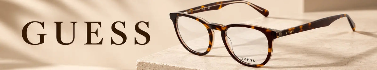 Guess GU50100 052 tortoiseshell eyeglasses on a premium beige Guess collection banner